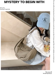 Detail view of khaki nylon tote bag with wide strap and subtle wrinkled texture finish
