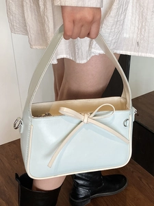 Sac seau bleu clair minimaliste avec bordure crème et détail élégant de nœud décoratif