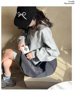 Street style view of grey sweatshirt with bow embroidery and black tote bag
