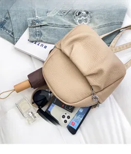 Detail view of beige lychee pattern mini backpack showing spacious interior capacity