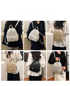Close-up of stylish mini faux leather backpacks in white, beige, black, and grey colors