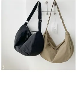 Detailed view of black and khaki large nylon crescent tote bags with adjustable straps