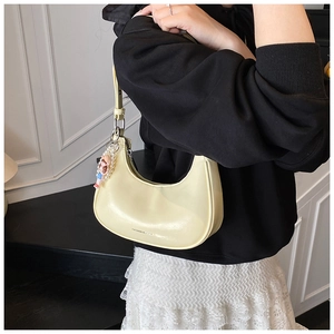 Détail du sac à bandoulière croissant jaune clair en cuir ciré avec breloque perle