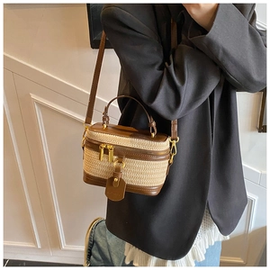 Detail showing natural straw weave and brown leather trim on a vintage box bag
