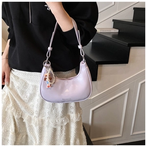 Détail du sac baguette violet en forme de croissant avec bandoulière et breloque perle