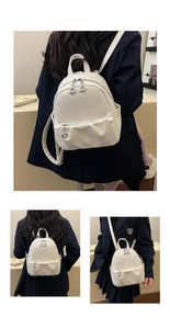 Close-up of white lychee textured small backpack showing dual silver zippers and side pockets