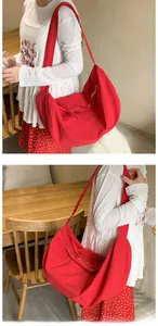 Detailed close-up of red hobo bag showing wrinkled nylon texture and zipper closure