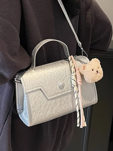 Minimalist silver textured handbag with metallic finish and cute bear charm for women