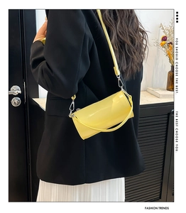 Detailansicht der leuchtend gelben Zylindertasche mit glänzendem Finish und Silberbeschlag