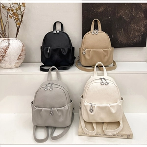 Detailed display of mini leather backpacks in black, khaki, gray, and cream white colors