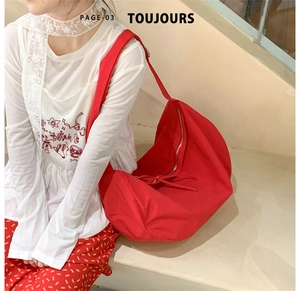 Top view of a large red crescent tote bag with zipper closure on a clean white background