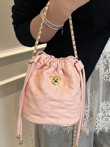 Sac seau matelassé rose avec chaîne dorée et emblème métallique pour femme élégante