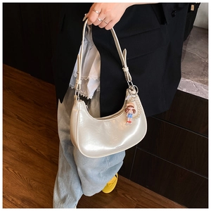 Détail du sac hobo en cuir ciré blanc crème avec pendentifs en perles et poupée