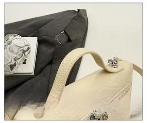 Close-up of cream white lychee grain leather handbag with metal zipper and D-ring buckle