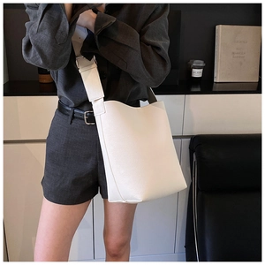 Vue détaillée du sac seau blanc avec texture cuir grainé et large bandoulière