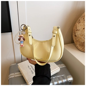 Détail du sac sous le bras jaune clair avec chaîne en perles et lettrage de mode