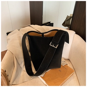 Detail der schwarzen minimalistischen Beuteltasche mit breitem Riemen und Silberschnalle