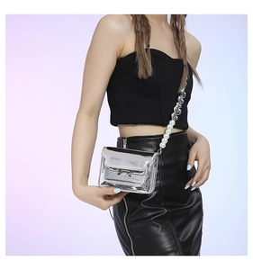 Detail of silver mirror crossbody bag with pearl and acrylic link shoulder strap