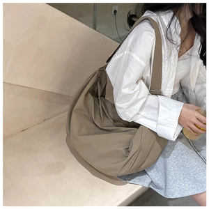 Macro shot of khaki nylon tote bag showing its natural pleated texture and strap