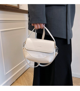 Detailed view of the cream white shoulder bag featuring a smooth finish and ZHCNMA logo