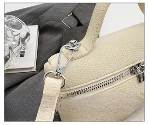 Close-up of premium silver hardware and lychee texture leather on cream handbag