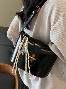 Minimalist black oil wax leather crossbody bag with golden lock and tassel charm