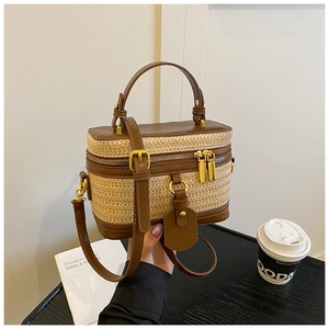 Macro view of woven straw texture and brown leather trim on a stylish box handbag