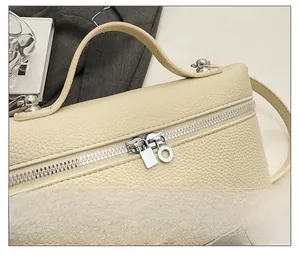 Detailed macro shot of smooth silver double zippers on a beige pebble leather handbag