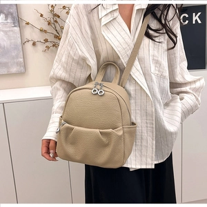 Detailed view of light khaki lychee pattern leather mini bag with double ring zippers