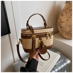Macro shot of a woven box bag featuring brown leather trim and golden metal hardware
