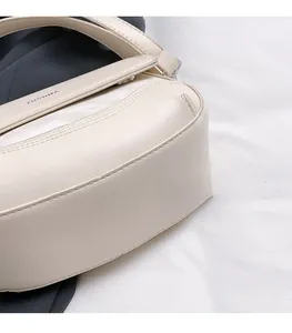 Close-up detail of cream faux leather shoulder bag with fine stitching and side construction
