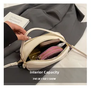 Interior view of white crossbody bag showing storage for phone and cosmetics