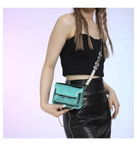 Detail of metallic mint green mini crossbody bag with pearl and heart chain strap