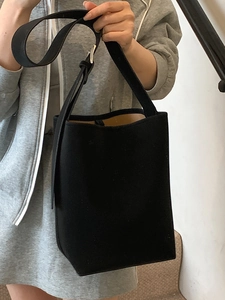Sac seau minimaliste en cuir noir mat avec bandoulière réglable pour un usage quotidien