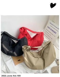 Detailed view of three nylon crescent bags in black, red and khaki with adjustable straps