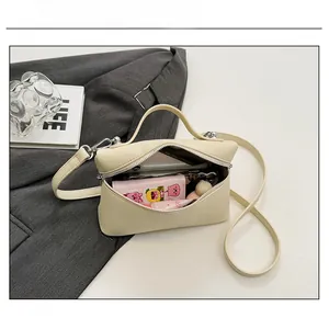 Internal capacity view of beige pebbled leather handbag with phone and cosmetics inside