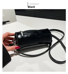 Detailansicht der schwarzen Zylindertasche aus Ölwachsleder mit glänzender Oberfläche