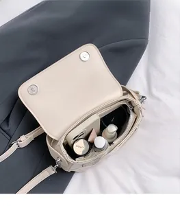 Detailed interior of minimalist cream saddle bag showing large capacity for essentials