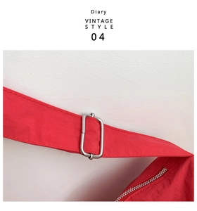 Detail of red vintage crossbody bag showing silver metal buckle and textured nylon fabric