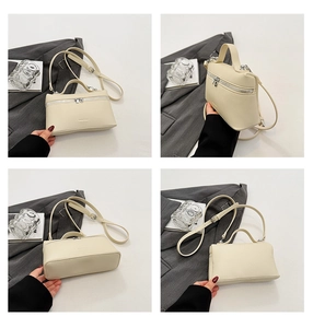 Detail view of a cream leather crossbody bag with lychee texture and silver hardware