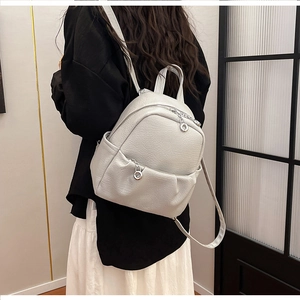 Back view of a light gray lychee pattern leather backpack with adjustable straps