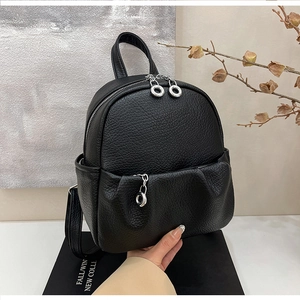 Detailed macro view of litchi-textured leather backpack with metallic silver zipper