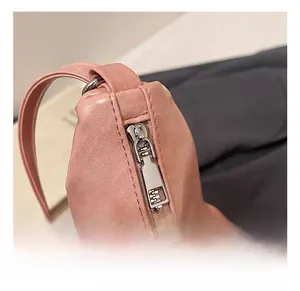 Close-up of pink leather tote bag with silver metal zipper and precise stitching details
