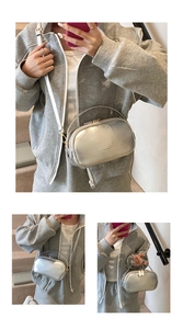 Detail of silver metallic Boston mini bag with dual zippers and adjustable shoulder strap