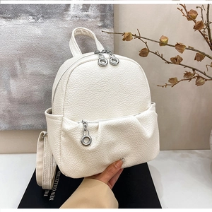 Close-up of white lychee pattern leather mini backpack with silver ring zipper details