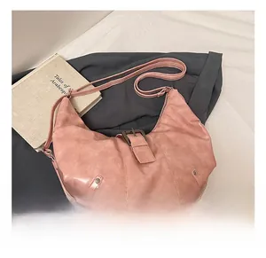 Close-up of pink hobo bag featuring retro leather texture and metal buckle detail