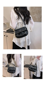 Detail of black leather saddle bag with white contrast stitching and silver hardware