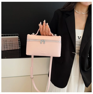 Detailed macro view of pink litchi grain leather small box bag with silver zipper