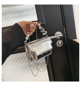 Chic silver mirror mini bag with heart chain and faux pearl handle detail shown in hand