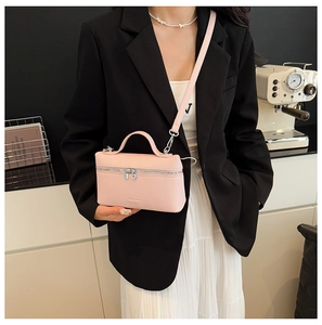Detail of pink lychee grain leather square bag with silver hardware and shoulder strap
